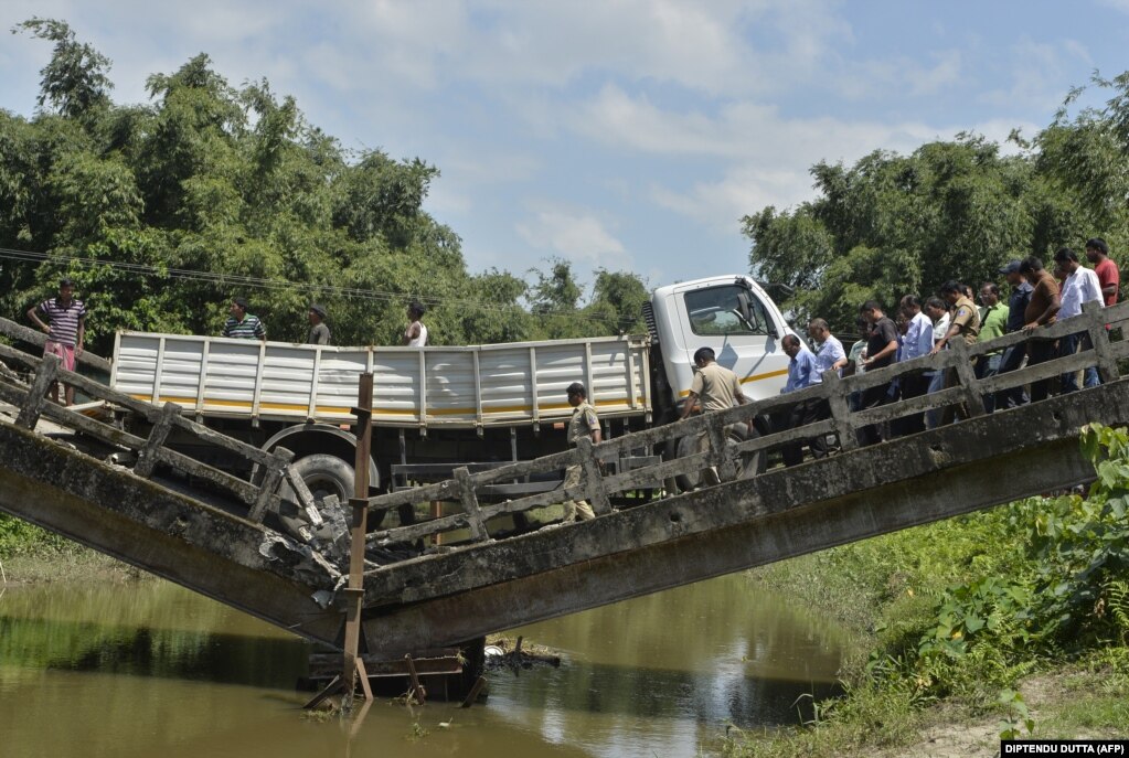 Indian rescue workers and villagers gather near a collapsed bridge in the Indian state of West Bengal. No casualties were reported in the collapse. (AFP/Diptendu Dutta)