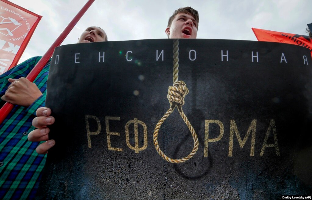 People shout slogans as they hold a poster reading "Pension Reform" during a Communist Party rally protesting hikes in the retirement age in St. Petersburg. Several thousand people gathered in central Moscow and St. Petersburg on September 2. Other demonstrations were reported in Vladivostok in the Far East and Barnaul and Novosibirsk in Siberia. (AP/Dmitri Lovetsky)
