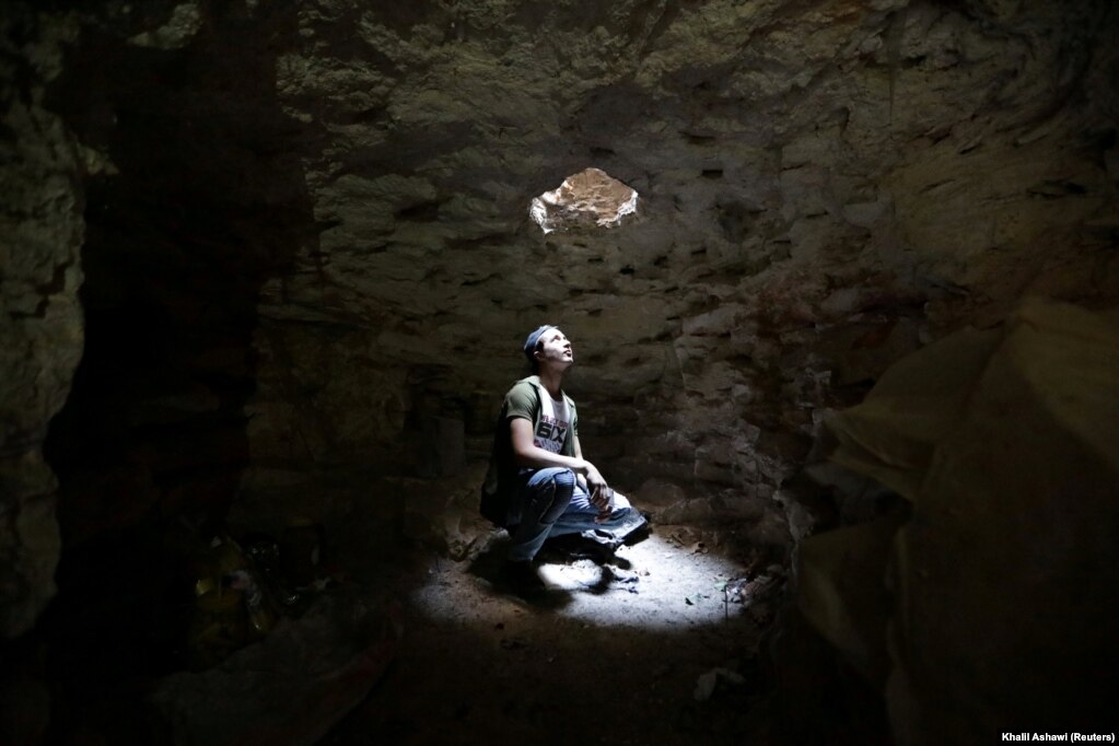 A man looks out of an opening of a makeshift shelter in an underground cave in Idlib, Syria. (Reuters/Khalil Ashawi)