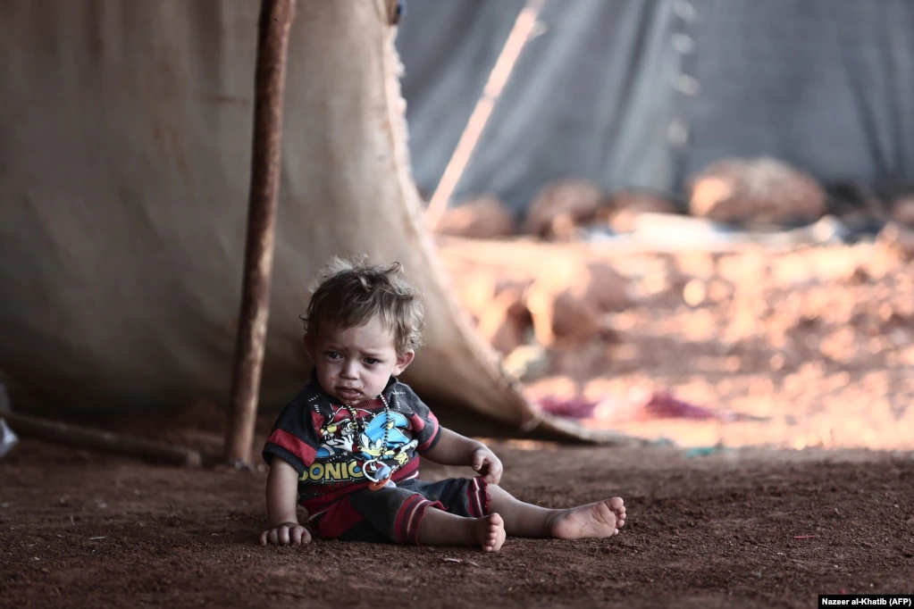 A child sits in front of a tent at a camp for the displaced from the rebel-held Syrian province of Idlib, in the village of Al-Ghadfa, southeast of the province. The Syrian regime and its ally Russia are threatening an offensive to retake the northwestern province, Syria's last rebel bastion. (AFP/Nazeer Al-Khatib)